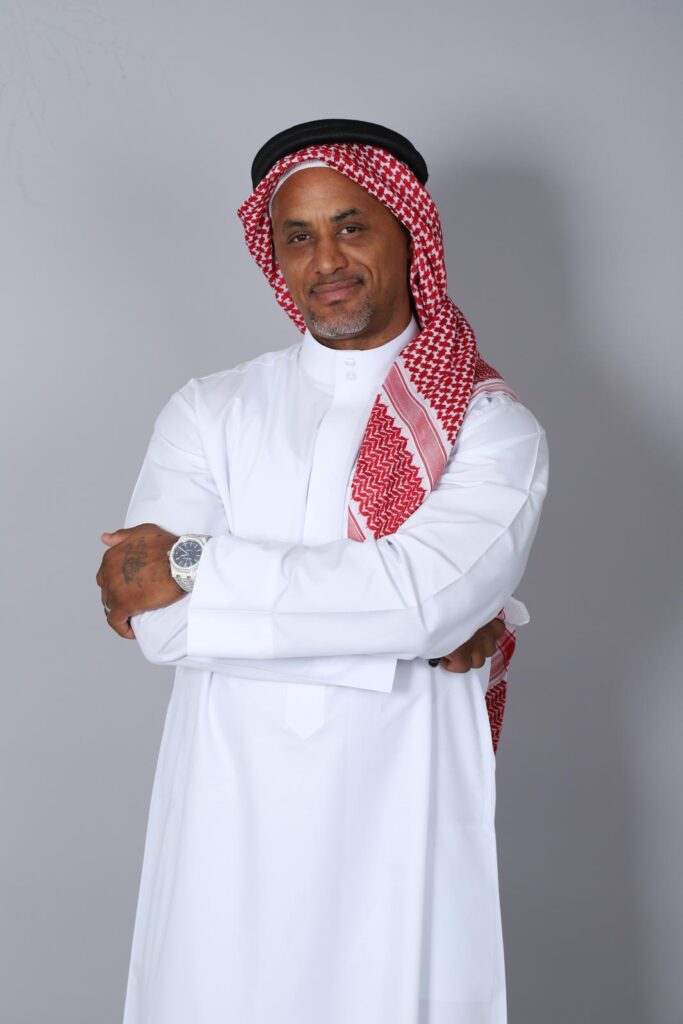 O. Abdullah Roberts in a white thobe and red-and-white shemagh
